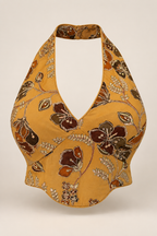 Mustard floral embroidered halter crop top with a deep neckline and curved hem, shown from the front.