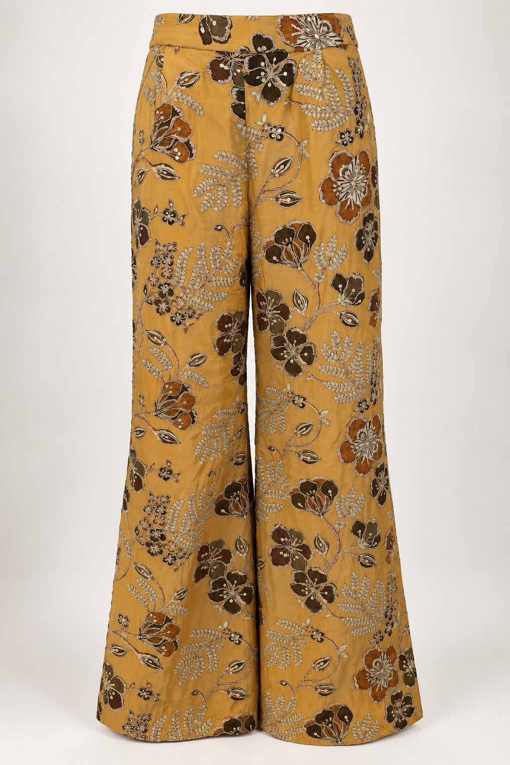 Mustard wide-leg palazzo trousers with brown and rust floral motifs and pale metallic embroidery.