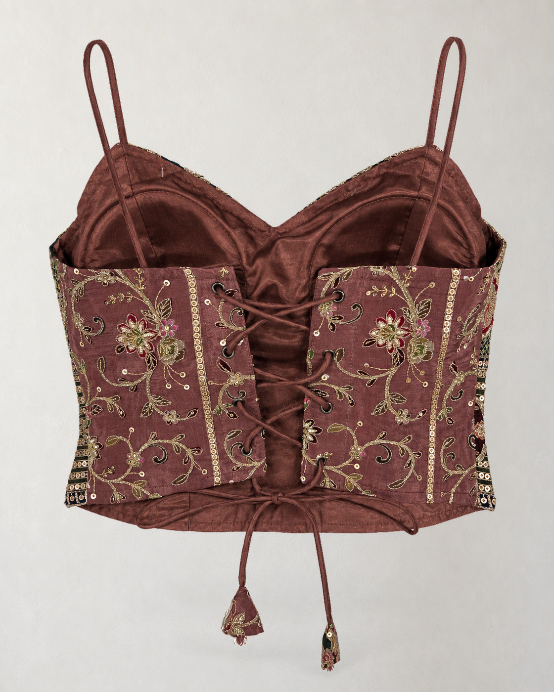 Digital garment presentation: Back of the cropped top with floral panels, eyelets, cross-lacing, hanging ties and visible inner lining.