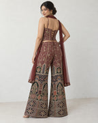 AI-styled model view: Rear three-quarter view of a woman looking over her shoulder, showing the lace-up top and flared trousers.