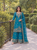 Model wearing the Teal Blue Fendy embroidered three-piece palazzo set in a garden.