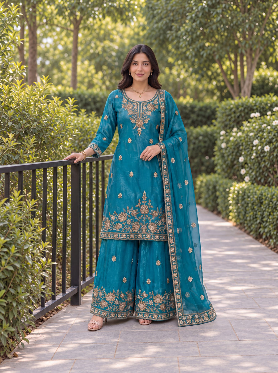 Model wearing the Teal Blue Fendy embroidered three-piece palazzo set in a garden.